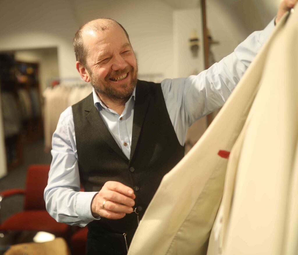 Geschäftsführer von Herrenmode Pöchhacker präsentiert einen Anzug