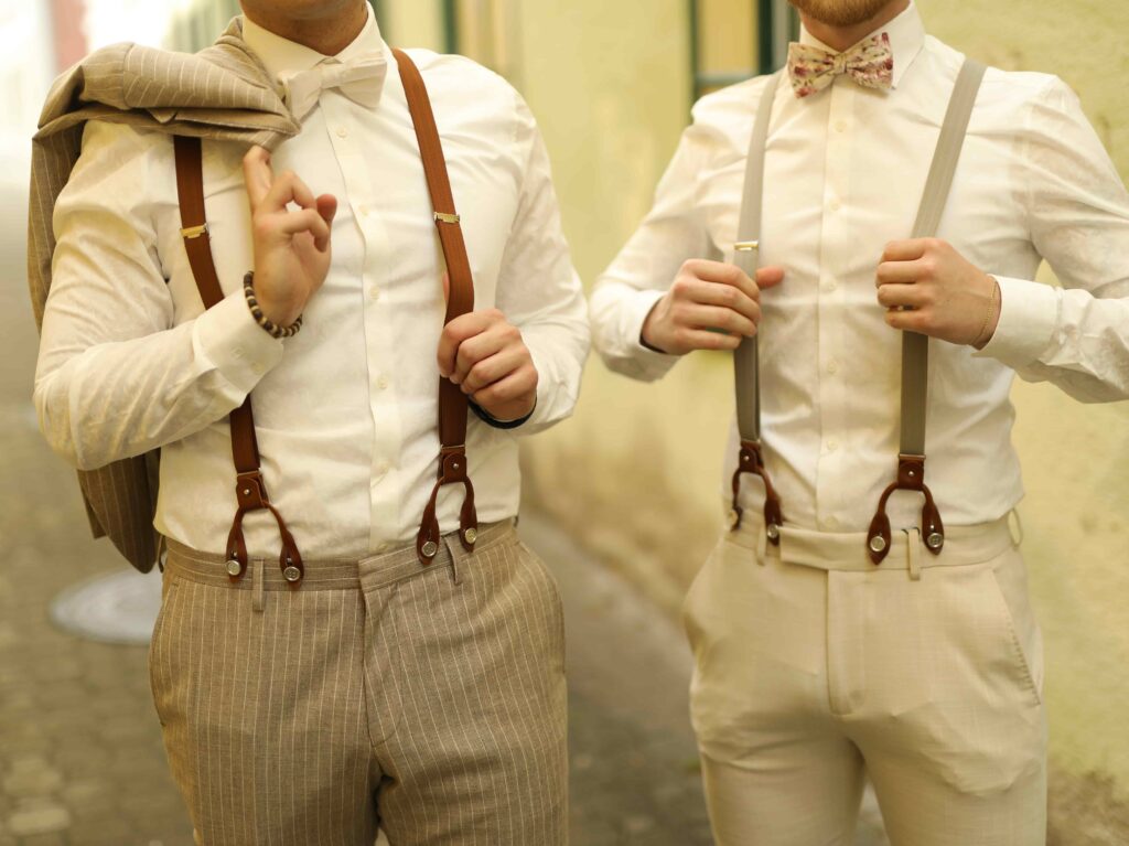zwei Männer präsentieren ihre neu gekauften Hosenträger zu ihrem Anzug