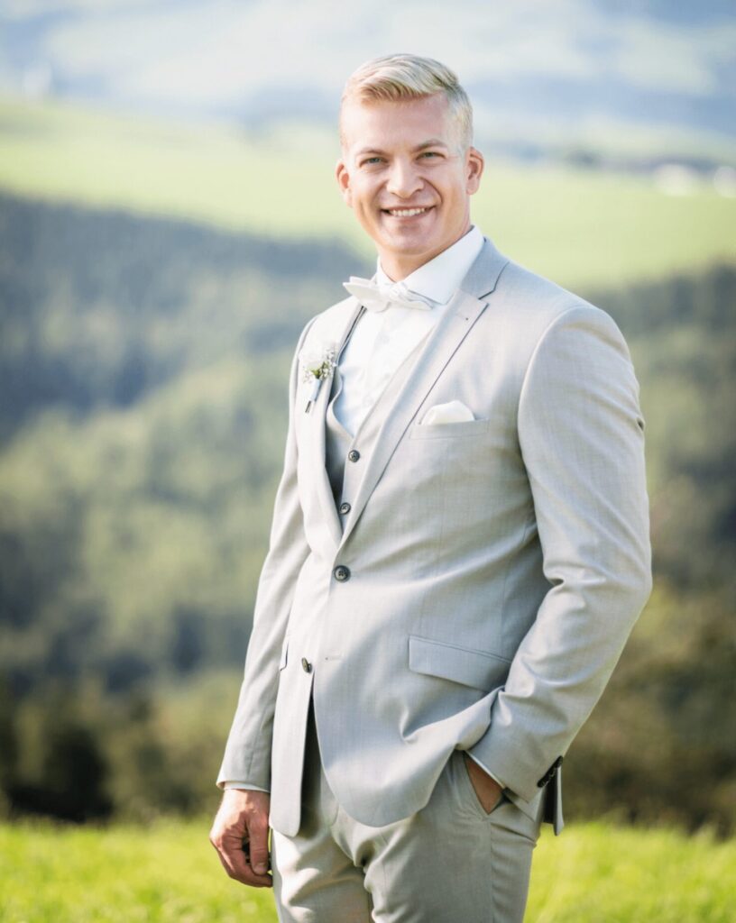 junger blonder Mann im grauen Hochzeitsanzug