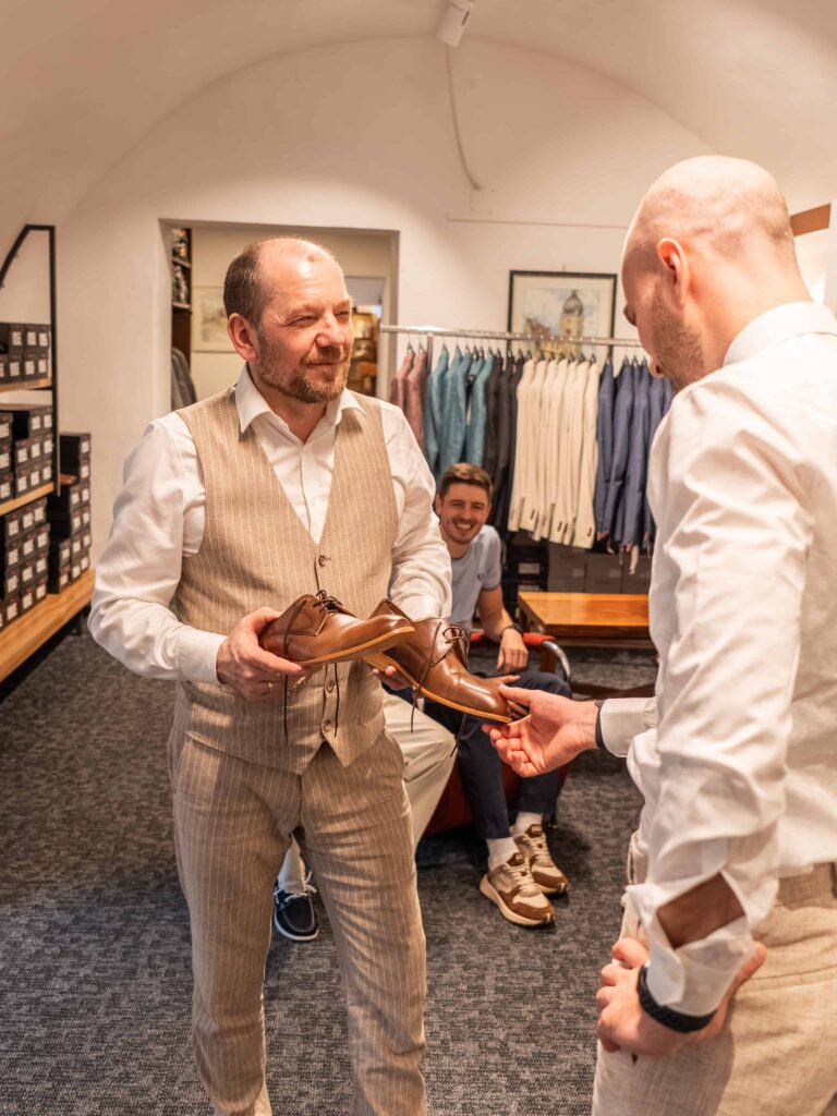 Geschäftsführer berät Kunden zu Hochzeitsschuhen