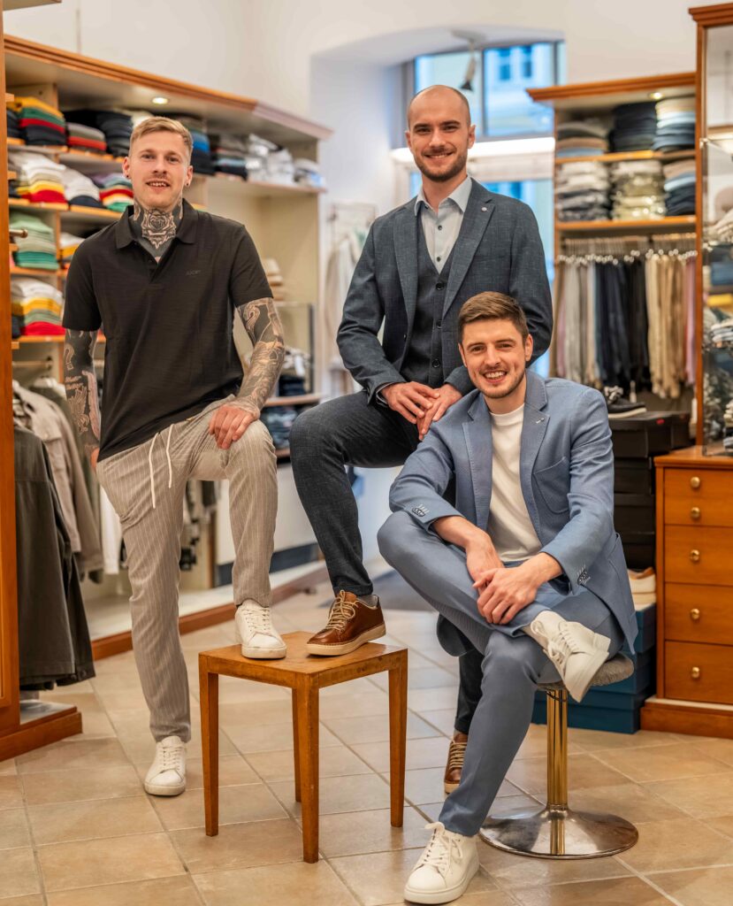 drei junge Männer präsentieren ihren neuen Anzug