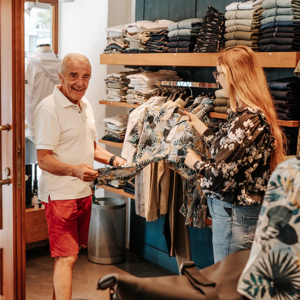 junge Frau berät älteren Herren zur Freizeitkleidung